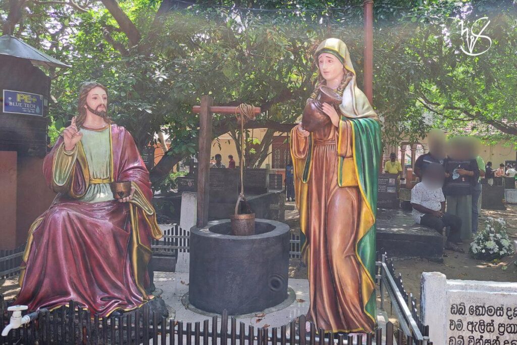 Photograph from a corner of the church, where a statue of the seated Christ and a Samaritan woman lie beside a small well. This is where the devotees draw out holy water to take with them.